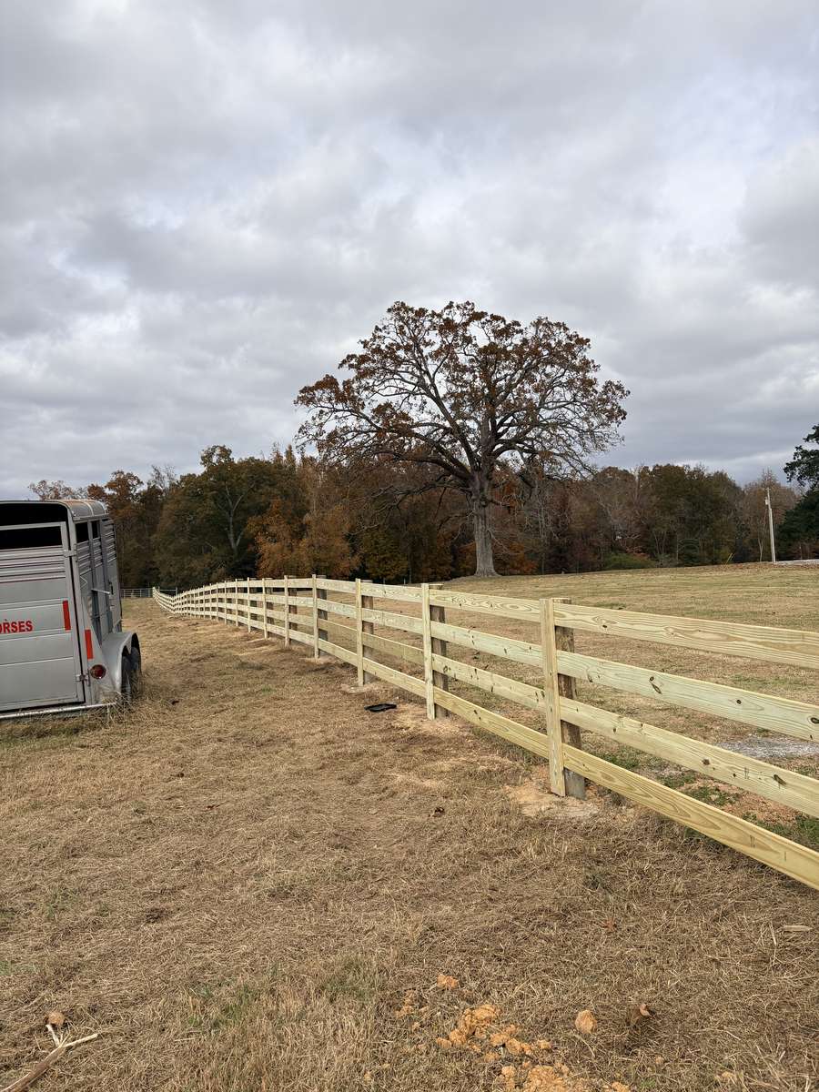 3-rail board fence with horse trailer